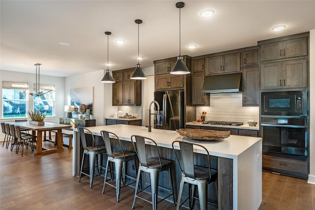 9122 Heckenberg Arbor Ln, Cypress, TX 77433 - kitchen featuring black appliances, under cabinet range hood, decorative backsplash, light countertops, and recessed lighting