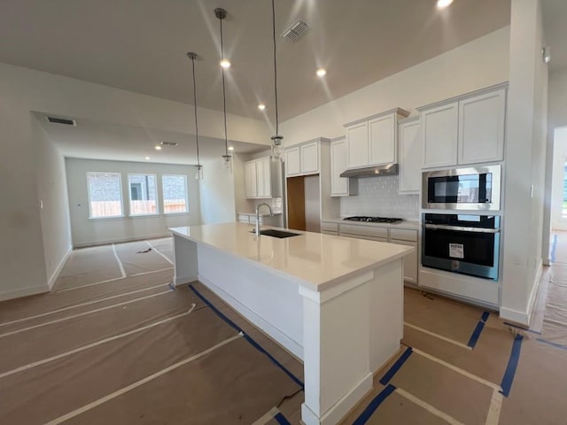 9122 Heckenberg Arbor Ln, Cypress, TX 77433 - kitchen with stainless steel appliances, decorative backsplash, white cabinetry, a spacious island, and recessed lighting
