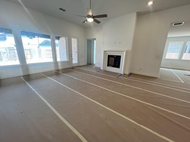 9122 Heckenberg Arbor Ln, Cypress, TX 77433 - unfurnished living room with a ceiling fan and a glass covered fireplace