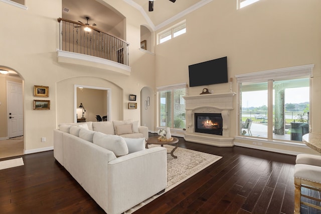 11702 Saporito Way, Richmond, TX 77406 - living area featuring a ceiling fan, crown molding, a towering ceiling, arched walkways, and dark wood finished floors