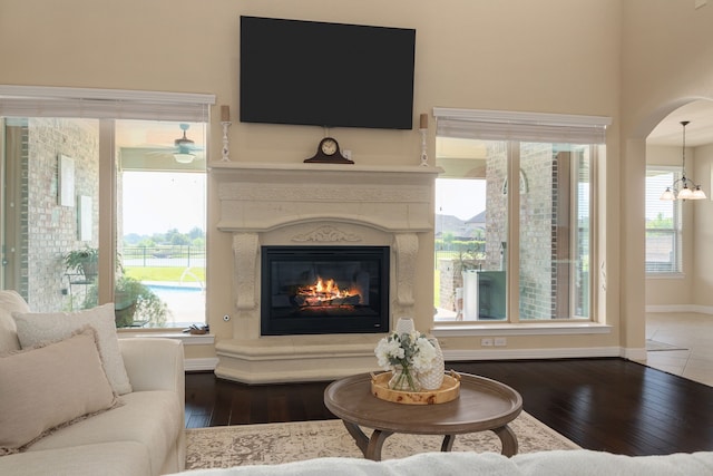 11702 Saporito Way, Richmond, TX 77406 - living room featuring hardwood / wood-style flooring, a glass covered fireplace, plenty of natural light, and a chandelier