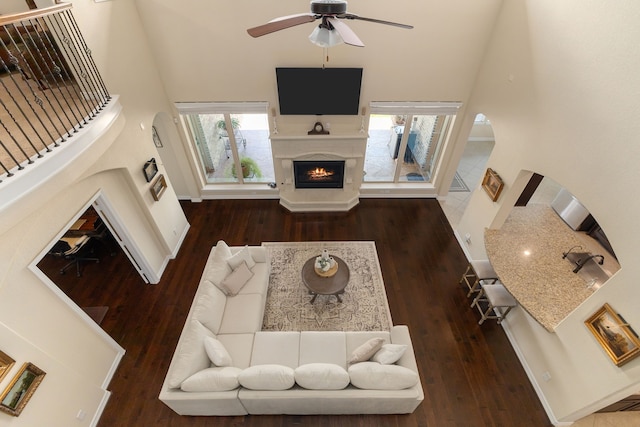 11702 Saporito Way, Richmond, TX 77406 - living room with a warm lit fireplace, hardwood / wood-style flooring, a ceiling fan, and a high ceiling