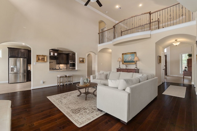 11702 Saporito Way, Richmond, TX 77406 - living room featuring ceiling fan, a towering ceiling, wood-type flooring, baseboards, and ornamental molding