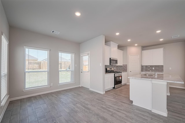 230 Emerald Thicket Ln, Huffman, TX 77336 - kitchen featuring stainless steel appliances, light wood-style floors, backsplash, baseboards, and recessed lighting