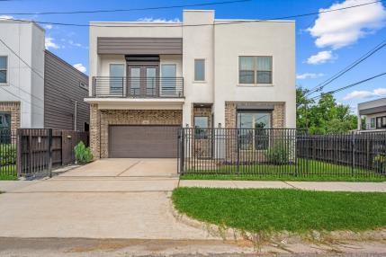 1804 Schweikhardt St, Houston, TX 77020 - view of front facade with a balcony, stucco siding, a garage, a fenced front yard, and concrete driveway