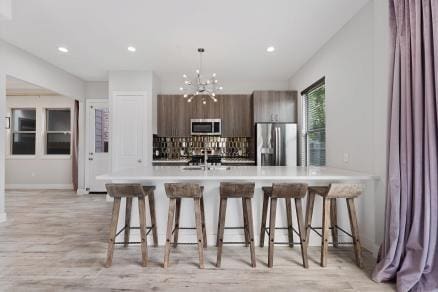 1804 Schweikhardt St, Houston, TX 77020 - kitchen featuring appliances with stainless steel finishes, a kitchen bar, modern cabinets, light countertops, and recessed lighting