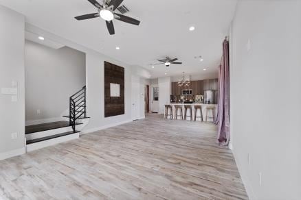 1804 Schweikhardt St, Houston, TX 77020 - unfurnished living room featuring a chandelier, light wood-type flooring, recessed lighting, ceiling fan, and stairway