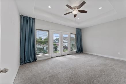 1804 Schweikhardt St, Houston, TX 77020 - unfurnished room featuring a tray ceiling, carpet floors, french doors, and recessed lighting