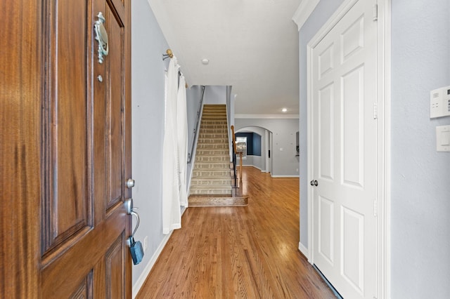 10106 Holly Chase Dr, Houston, TX 77042 - foyer featuring arched walkways, baseboards, ornamental molding, light wood finished floors, and stairway