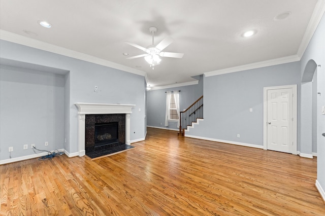 10106 Holly Chase Dr, Houston, TX 77042 - unfurnished living room with a ceiling fan, crown molding, a high end fireplace, light wood-style flooring, and stairway