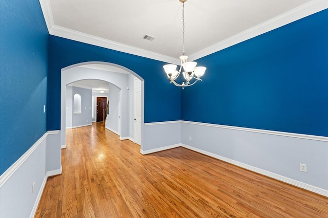 10106 Holly Chase Dr, Houston, TX 77042 - unfurnished room featuring a chandelier, wood finished floors, ornamental molding, arched walkways, and baseboards