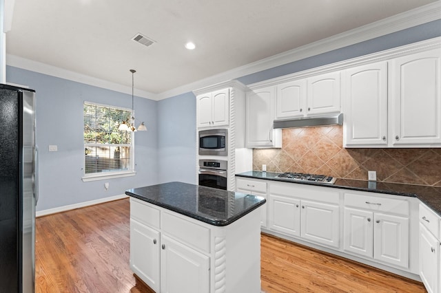 10106 Holly Chase Dr, Houston, TX 77042 - kitchen with stainless steel appliances, under cabinet range hood, crown molding, white cabinetry, and recessed lighting