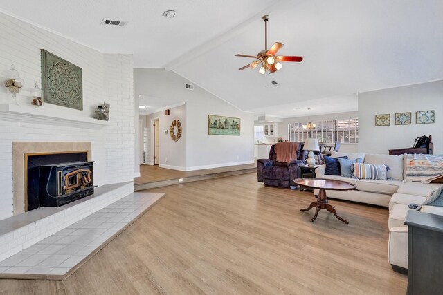 148 S Oak Bluff St, Trinity, TX 75862 - living room featuring light wood-type flooring, ceiling fan, baseboards, a chandelier, and a wood stove