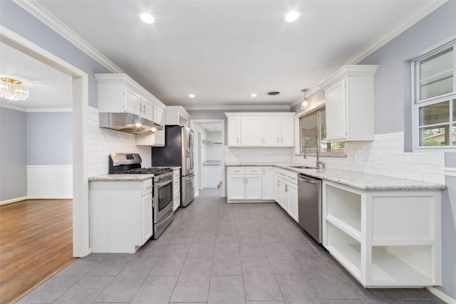 8022 Ridgeview Dr, Houston, TX 77055 - kitchen featuring appliances with stainless steel finishes, under cabinet range hood, a sink, white cabinets, and backsplash