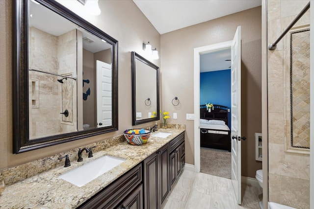 8309 Cook Rd, Manvel, TX 77578 - bathroom featuring toilet, a tile shower, ensuite bathroom, double vanity, and marble finish flooring