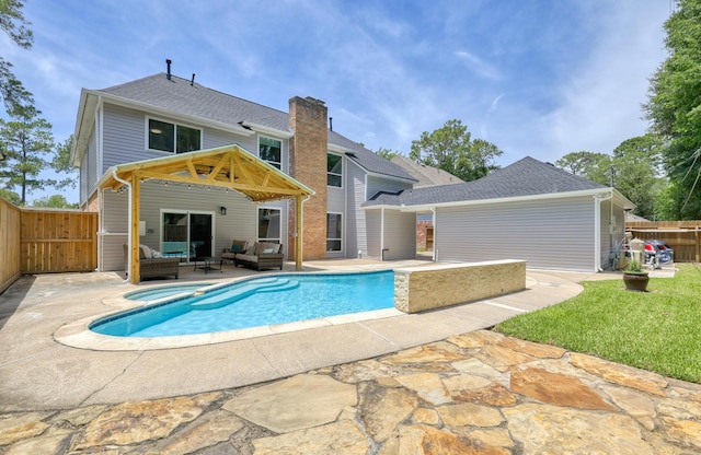 17706 August Meadows Ln, Spring, TX 77379 - back of property featuring an outdoor hangout area, a patio area, a pool with connected hot tub, and a gate