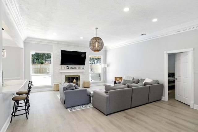 17706 August Meadows Ln, Spring, TX 77379 - living room with crown molding, light wood-style flooring, baseboards, a stone fireplace, and recessed lighting