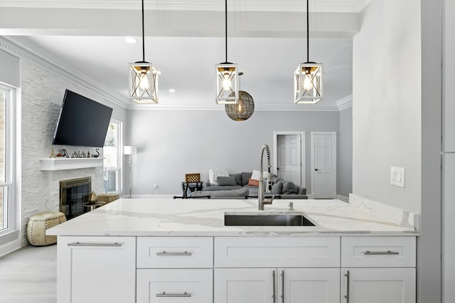 17706 August Meadows Ln, Spring, TX 77379 - kitchen featuring a sink, open floor plan, white cabinetry, light stone countertops, and crown molding