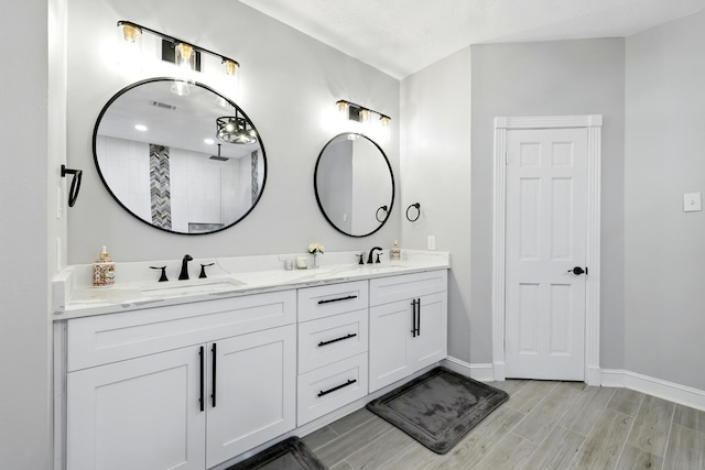 17706 August Meadows Ln, Spring, TX 77379 - full bath with double vanity, baseboards, wood finish floors, and tiled shower