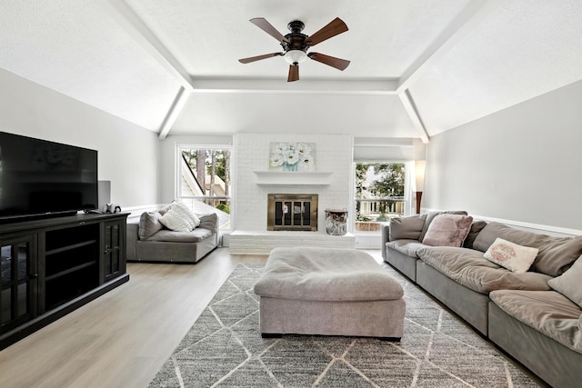 17706 August Meadows Ln, Spring, TX 77379 - living room with vaulted ceiling, healthy amount of natural light, a ceiling fan, a fireplace, and wood finished floors