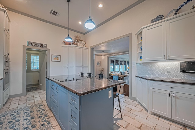 500 W Post Office St, Eagle Lake, TX 77434 - kitchen featuring black electric stovetop, tasteful backsplash, a kitchen bar, a center island, and recessed lighting
