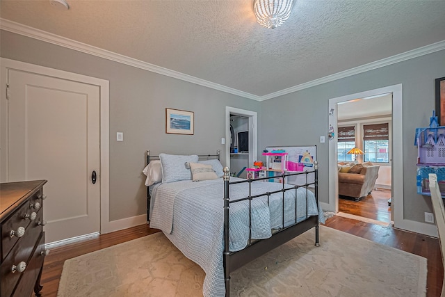 500 W Post Office St, Eagle Lake, TX 77434 - bedroom with wood finished floors, crown molding, a textured ceiling, and baseboards