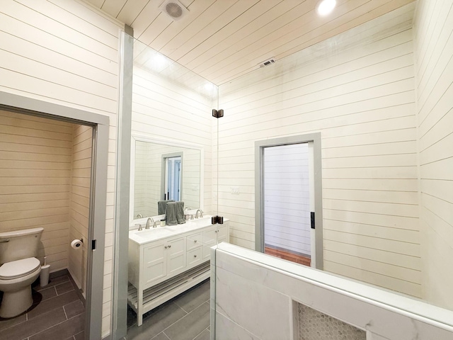 1111 Fm 109, New Ulm, TX 78950 - full bath featuring toilet, tile patterned flooring, double vanity, wood walls, and recessed lighting