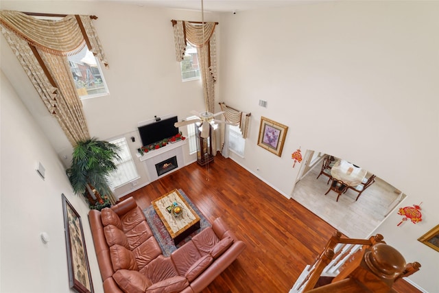 6610 Golden View Ct, Houston, TX 77083 - living area with a high ceiling, wood finished floors, a warm lit fireplace, and baseboards
