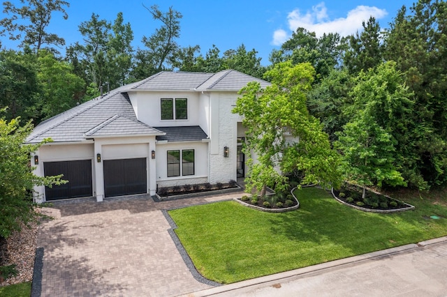 19 Pronghorn Pl, The Woodlands, TX 77389 - modern farmhouse featuring decorative driveway, a garage, stucco siding, a front lawn, and a tiled roof