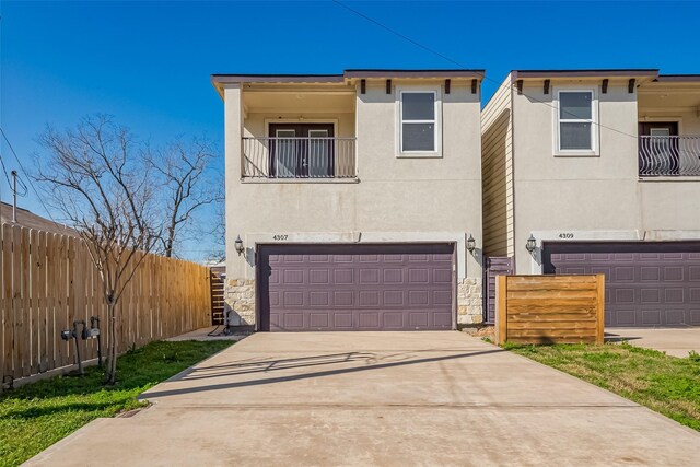 4307 Hershe St, Houston, TX 77020 - view of front of home with a balcony, a garage, stucco siding, and concrete driveway