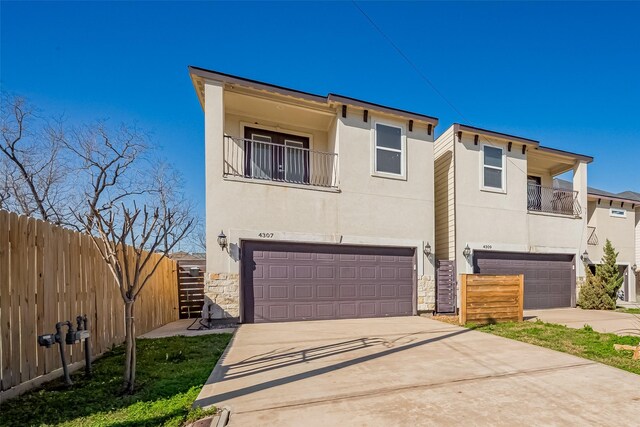 4307 Hershe St, Houston, TX 77020 - view of front of property with an attached garage, a balcony, stone siding, and driveway