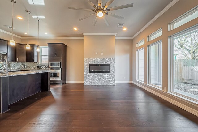 4307 Hershe St, Houston, TX 77020 - kitchen featuring stainless steel appliances, dark brown cabinetry, dark wood-style floors, decorative backsplash, and ceiling fan