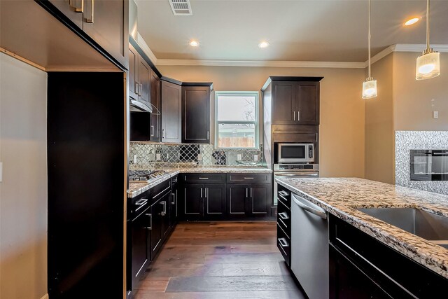 4307 Hershe St, Houston, TX 77020 - kitchen with stainless steel appliances, crown molding, light stone countertops, dark wood finished floors, and tasteful backsplash