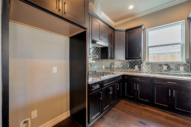4307 Hershe St, Houston, TX 77020 - kitchen with ornamental molding, dark wood-style floors, light stone counters, decorative backsplash, and under cabinet range hood