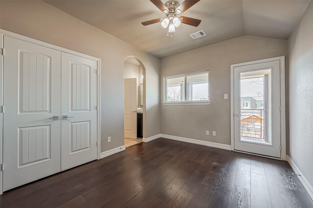 4307 Hershe St, Houston, TX 77020 - unfurnished bedroom featuring dark wood-style flooring, arched walkways, ensuite bathroom, lofted ceiling, and baseboards
