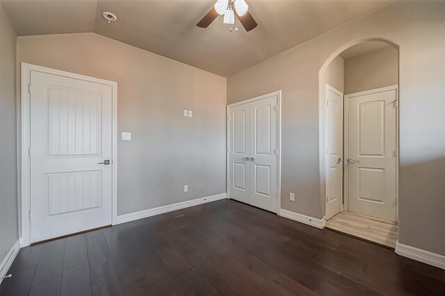 4307 Hershe St, Houston, TX 77020 - unfurnished bedroom featuring dark wood-style floors, baseboards, vaulted ceiling, arched walkways, and a ceiling fan
