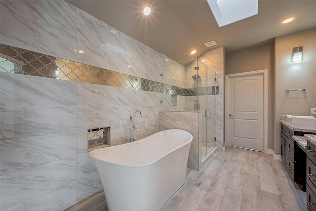 4307 Hershe St, Houston, TX 77020 - bathroom featuring a stall shower, a freestanding bath, vanity, vaulted ceiling, and a skylight