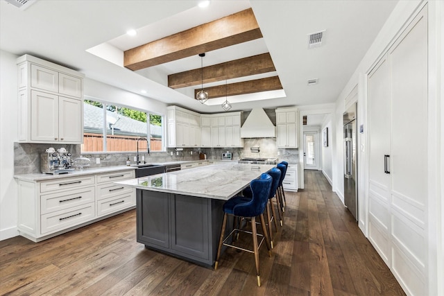 1702 De Milo Dr, Houston, TX 77018 - kitchen with a tray ceiling, premium range hood, a sink, a center island, and tasteful backsplash