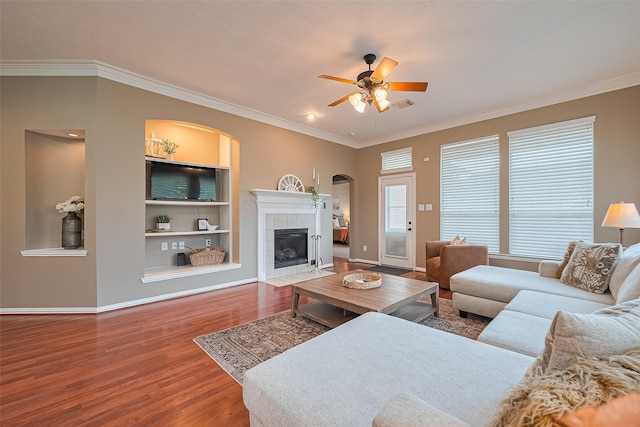 2500 Amy Lee Dr, Conroe, TX 77304 - living area with wood finished floors, a ceiling fan, ornamental molding, arched walkways, and built in features