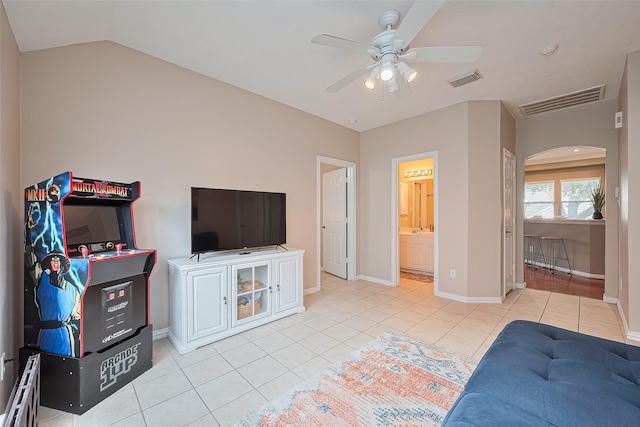 2500 Amy Lee Dr, Conroe, TX 77304 - bedroom featuring arched walkways, light tile patterned flooring, a ceiling fan, ensuite bathroom, and vaulted ceiling