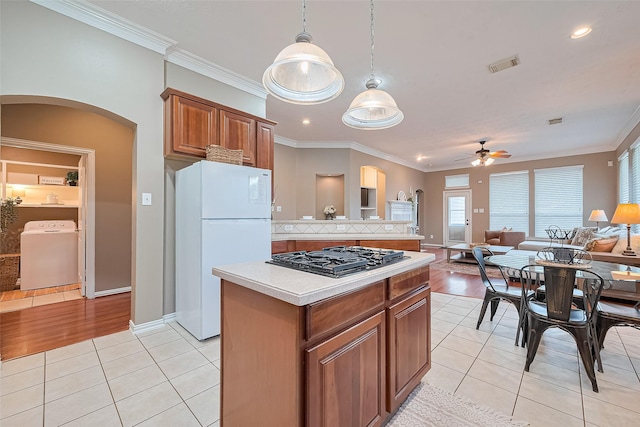 2500 Amy Lee Dr, Conroe, TX 77304 - kitchen with washer / dryer, freestanding refrigerator, gas stovetop, arched walkways, and ceiling fan