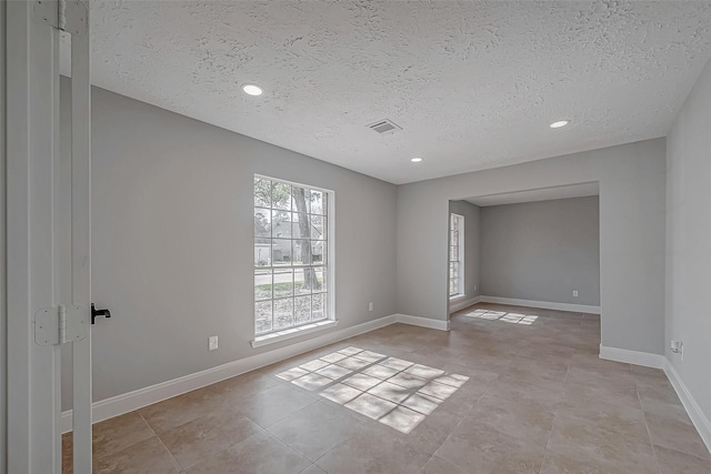 9602 John Bank Dr, Spring, TX 77379 - unfurnished room with a textured ceiling, baseboards, recessed lighting, and light tile patterned floors