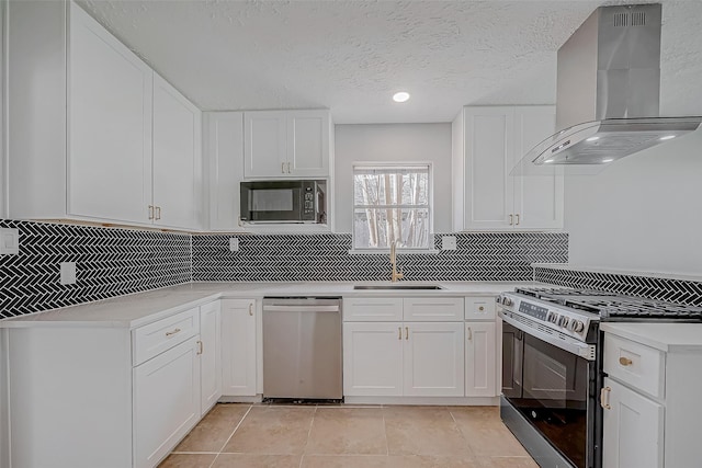 9602 John Bank Dr, Spring, TX 77379 - kitchen featuring wall chimney exhaust hood, appliances with stainless steel finishes, a sink, tasteful backsplash, and white cabinets