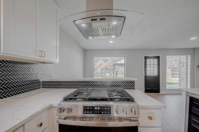 9602 John Bank Dr, Spring, TX 77379 - kitchen featuring stainless steel gas range, white cabinets, backsplash, beverage cooler, and recessed lighting