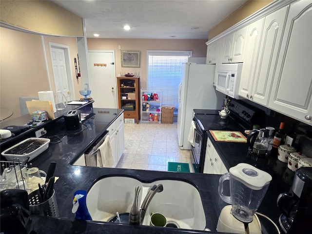 2503 Mccue Rd Unit 13, Houston, TX 77056 - kitchen with black range with electric stovetop, white microwave, dark countertops, and white cabinets