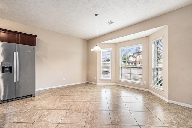 30710 Basil Trace Dr, Spring, TX 77386 - unfurnished dining area featuring healthy amount of natural light, a textured ceiling, baseboards, and light tile patterned flooring
