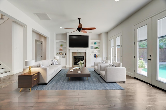 2209 Macarthur St, Houston, TX 77030 - living area featuring french doors, wood finished floors, ceiling fan, built in features, and a fireplace
