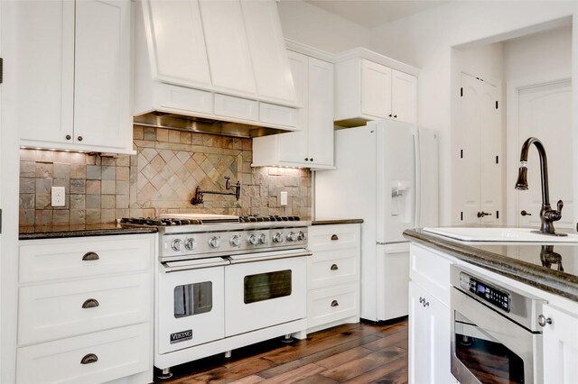 2209 Macarthur St, Houston, TX 77030 - kitchen featuring white appliances, custom range hood, a sink, dark wood finished floors, and decorative backsplash