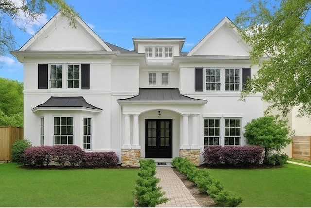 2209 Macarthur St, Houston, TX 77030 - view of front of property featuring a standing seam roof, french doors, stucco siding, stone siding, and a metal roof