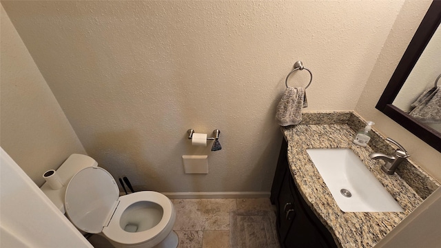 1805 Stoney Brook Dr Unit 103, Houston, TX 77063 - bathroom featuring toilet, vanity, baseboards, and stone finish floors